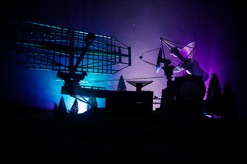 Silhouettes of satellite dishes or radio antennas against night sky. Space observatory.