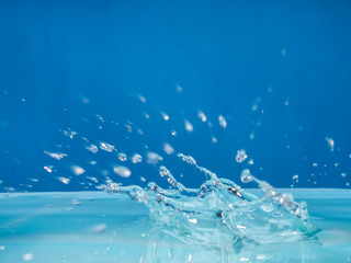 Fototapeta na wymiar Clean water droplets against the blue background