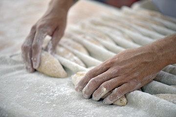 Obraz na płótnie Canvas The baker shapes the bread to be baked