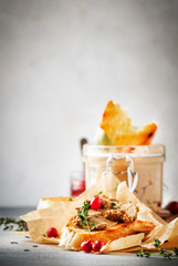 Delicious pate of chicken liver and meat on grilled toasts with cranberries and thyme, gray kitchen table background, space for text, selective focus