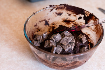 Chocolate pieces being mixed into brownie mixture