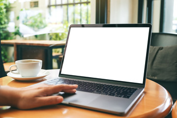 Mockup image of a woman using and touching laptop touchpad with blank white desktop screen