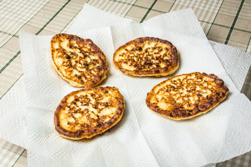 Curd cheesecakes on white napkin to absorb excess oil.