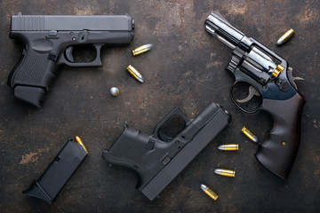 Gun with ammunition on iron dark background.