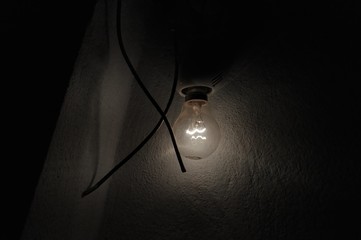 Electric bulb glowing in a dark room