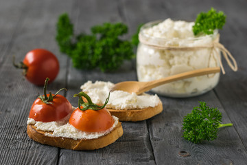 Cherry tomatoes and cottage cheese on a wooden table.
