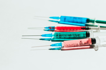 Obraz premium syringes with multicolored liquid on a white background.