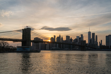 Naklejka na ściany i meble scene of New york Cityscape with Brooklyn Bridge over the east river at the sunset time, USA downtown skyline, Architecture and transportation concept