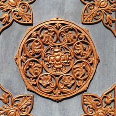 Textured golden metal pattern on a gray metal surface.