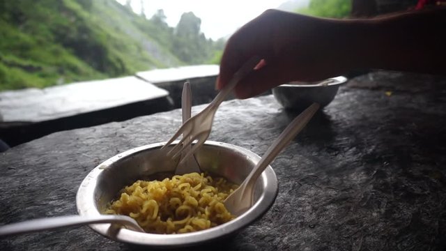 Steaming hot ramen noodles in a steel bowl served at a small restaurant on triund bhagsu falls trek in the himalayas