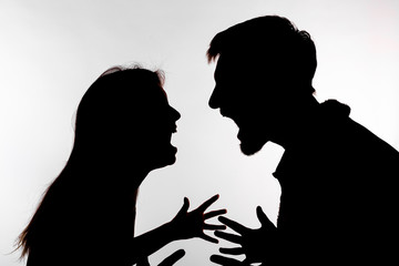 Aggression and abuse concept - man and woman expressing domestic violence in studio silhouette isolated on white background.