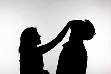 Aggression and abuse concept - man and woman expressing domestic violence in studio silhouette isolated on white background.