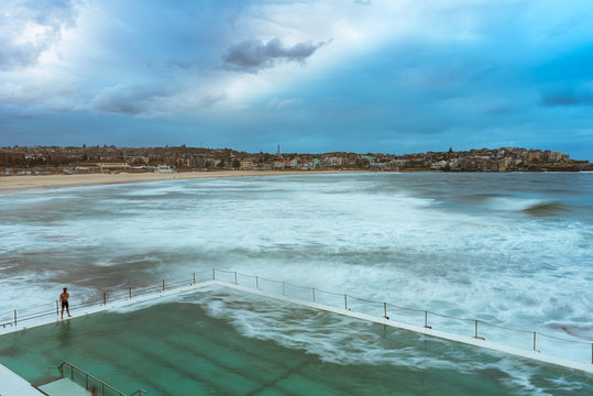 lone man at bondi icebergs pool and bondi beach golden sand