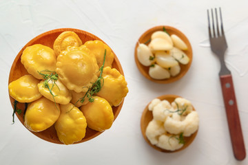 Salty squash in wooden plates on a background of fermented products on a white table. Close-up. Top view