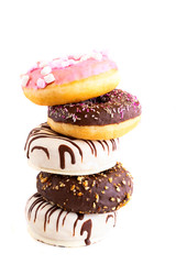 Fresh donuts with different frosted, chocolate, pink glazed and sprinkles on white background with copy space. Assortment of various colourful donuts.