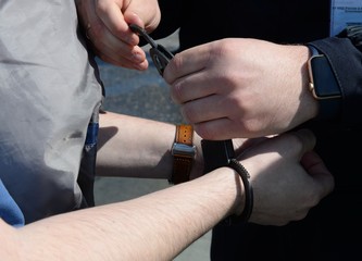 Buttoning the police steel handcuffs on the hands of men