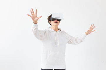 Positive pretty middle-aged woman in a white sweater watching a movie with glasses of virtual...