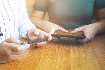 Two young woman playing game in mobile smartphone together.