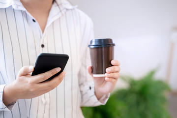 Woman hands holding mobile smartphone in cafe.