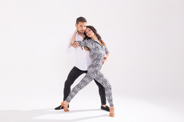 Social dance concept - Active happy adults dancing bachata or salsa together over white background with copy space