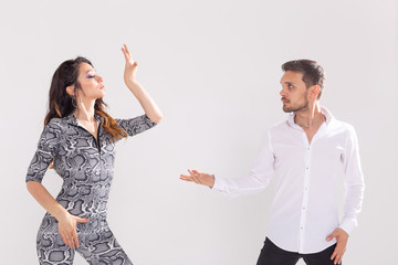 Young couple dancing social latin dance bachata, merengue, salsa. Two elegance pose on white...