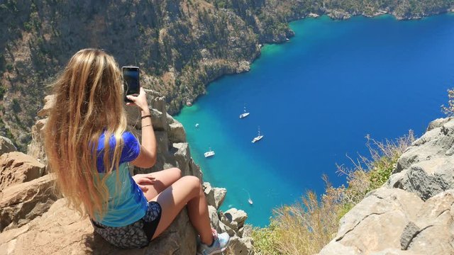 Woman traveller enjoying beautiful view of The Butterfly Valley from the top of the mountain