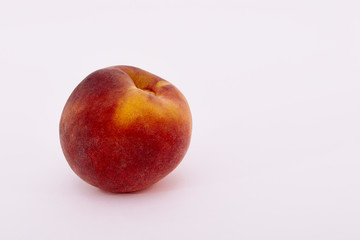 Single ripe peach fruit on white