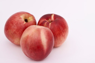 Three ripe peaches on white