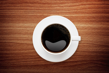 Black coffee in white coffeecup put on wooden table ,top view and coppy space.