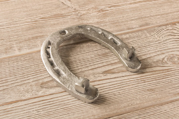 Silver horseshoe on a wooden table. An old horseshoe.
