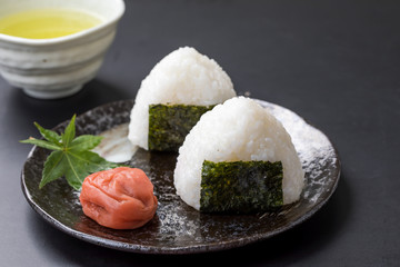 黒背景におにぎりと梅干しとお茶高級感日本食コピースペース