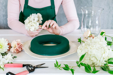 Woman shows how to make wedding table decoration with wreath and candle