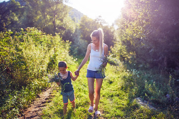 Mother and son picking flowers / herbs in nature.