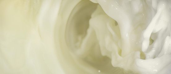 Splashes of liquid milk on a long horizontal background is macro