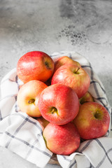 Apples in a basket on a gray background. Autumn harvest