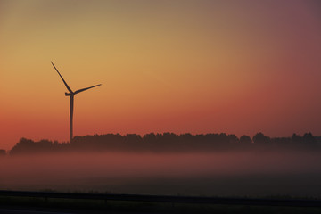 Obraz premium Wind farm in the field at dawn.