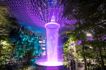 Jewel Changi Airport Rain Vortex, the largest indoor waterfall in the world and the centerpiece of Jewel Changi Airport by night - obrazy, fototapety, plakaty