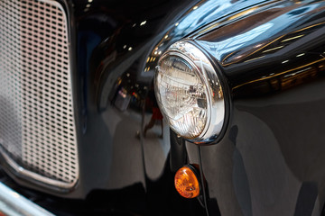 Close up headlight of a black vintage car
