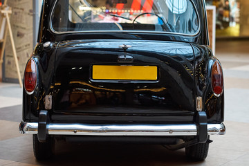 Closeup of a black vintage car.  Back view part of retro car