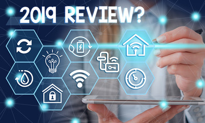 Conceptual hand writing showing 2019 Review Question. Concept meaning remembering past year events main actions or good shows Female human wear formal work suit presenting smart device