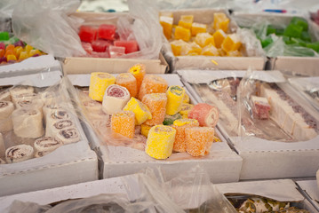 Turkish national sweets are sold at the fair. Multi-colored Asian desserts stacked on the table. Rahat lokum in bulk is sold at the festival.