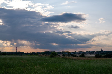 Obraz na płótnie Canvas Natural sunset over field or meadow. Bright dramatic sky and dark ground.