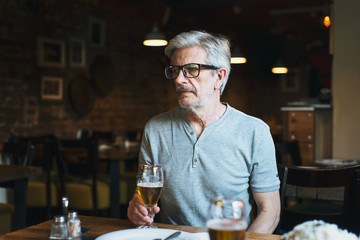 Senior man having a beer in the bar