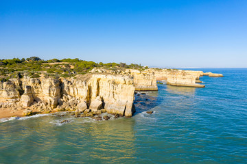 Obraz premium Vue aérienne sur les côtes rocheuses à proximité de Albufeira. On y voit les falaises rocheuses et les plages typiques de la côte du sud du Portugal.