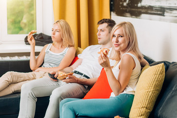 Friends eating pizza and talking, spending time together at home