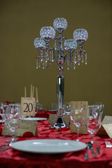Formal table setting for a wedding or a special event featuring a timeless five bobeche crystal candelabra centerpiece, white china, invitation cards, glassware and silverware in the order of use