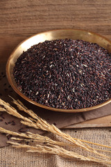 riceberry rice in golden tray on table with a blank space for a text, riceberry rice in kitchen background