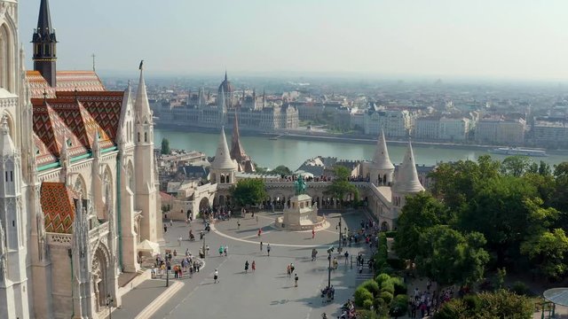 Budapest, Hungary - 4K drone flying at Fisherman's Bastion by Matthias Church with clocktower and Parliament of Hungary at background on a sunny summer day