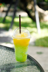 Mango and melon smoothie in a plastic cup at cafe