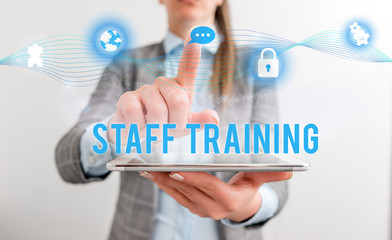 Conceptual hand writing showing Staff Training. Concept meaning program that helps employees learn specific knowledge Female human wear formal work suit presenting smart device